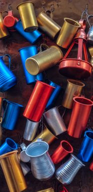 Duvarda asılı renkli metal bardaklar