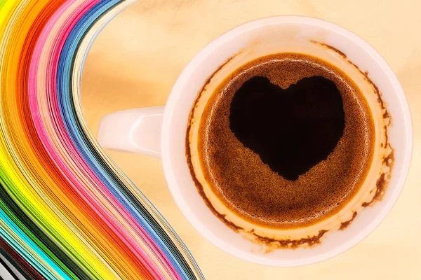 Color wave curl rainbow strip paper and coffee mug with hot instant coffee foam heart-shaped