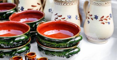 Masanın üzerine seramik kaplar yerleştirilmiş.