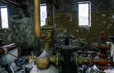 Boruları ve muslukları olan terk edilmiş sanayi bölgesi