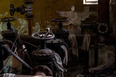 Boruları ve muslukları olan terk edilmiş sanayi bölgesi