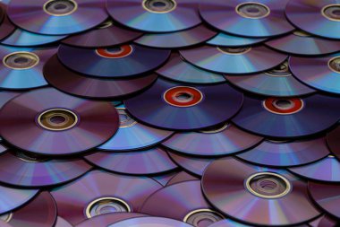 Düz bir yüzeye dizilmiş arkaplan CD 'leri ve DVD diskleri