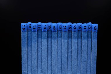 Kafalarında yüzler olan mavi kibrit çöpleri.