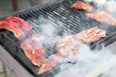 Kızarmış Sulu et, barbeküde kömürün üstünde pişiyor.