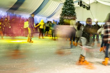 Malaga, İspanya - 08 Aralık 2017. Birçok insan kış gecesi büyük buz pistinde kayar, hareket bulanıklığı