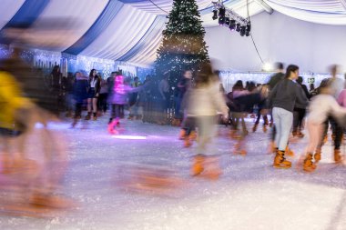 Malaga, İspanya - 08 Aralık 2017. Birçok insan kış gecesi büyük buz pistinde kayar, hareket bulanıklığı