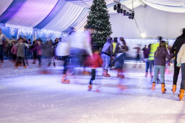 Malaga, İspanya - 08 Aralık 2017. Birçok insan kış gecesi büyük buz pistinde kayar, hareket bulanıklığı