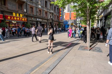 Şangay, Çin - 26 Nisan 2025 muhteşem şehir Şangay 'da yürüyüş turu, hareketli bir şehir sokak sahnesi. Gündelik giysiler içinde kaldırımda yürüyen çeşitli kadın ve erkeklerden oluşan bir kalabalık.