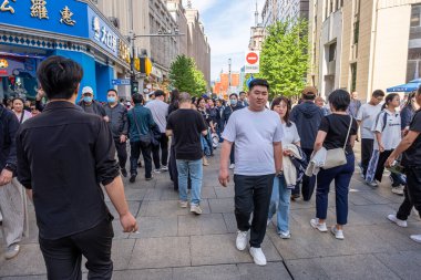 Şangay, Çin - 26 Nisan 2025 muhteşem şehir Şangay 'da yürüyüş turu, hareketli bir şehir sokak sahnesi. Gündelik giysiler içinde kaldırımda yürüyen çeşitli kadın ve erkeklerden oluşan bir kalabalık.