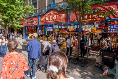 Şangay, Çin - 26 Nisan 2025 muhteşem şehir Şangay 'da yürüyüş turu, hareketli bir şehir sokak sahnesi. Gündelik giysiler içinde kaldırımda yürüyen çeşitli kadın ve erkeklerden oluşan bir kalabalık.