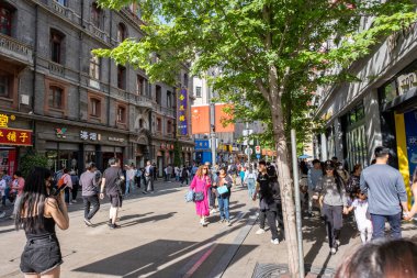 Şangay, Çin - 26 Nisan 2025 muhteşem şehir Şangay 'da yürüyüş turu, hareketli bir şehir sokak sahnesi. Gündelik giysiler içinde kaldırımda yürüyen çeşitli kadın ve erkeklerden oluşan bir kalabalık.