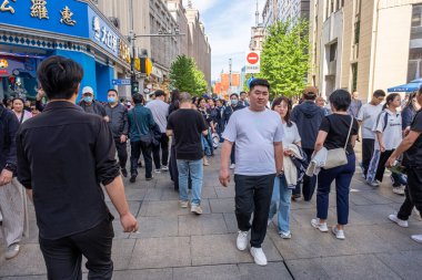 Şangay, Çin - 26 Nisan 2025 muhteşem şehir Şangay 'da yürüyüş turu, hareketli bir şehir sokak sahnesi. Gündelik giysiler içinde kaldırımda yürüyen çeşitli kadın ve erkeklerden oluşan bir kalabalık.