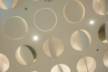 Birden fazla dairesel kesikle süslenmiş bir tavan. Tavan yumuşak, krem rengine boyanmış. Dairesel kesikler eşit aralıklarla çizilmiş. Bu da ışık ve gölge deseni yaratıyor..
