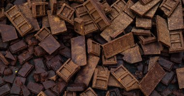 Her biri karmaşık dikdörtgen desenlere sahip kaotik koyu kahverengi, paslı ve yıpranmış çikolata kalıpları. Bloklar rastgele dağılmış, dokulu ve yoğun bir yüzey oluşturmuş.