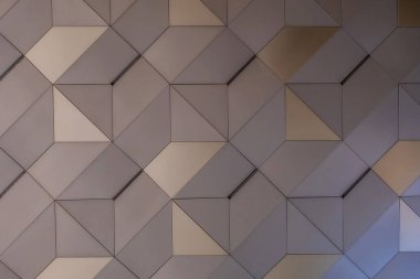 Tekrarlayan altıgen dizaynlı bir geometrik duvar deseni. Altıgenler, gri ve bejin çeşitli tonlarından oluşur ve ince gölgelerle üç boyutlu bir etki yaratır.