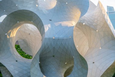 Geniş, dairesel kesimlere sahip karmaşık dalga benzeri bir tasarıma sahip modern bir mimari yapı. Binanın dışı düz, açık gri betondan ve ince doku çizgilerinden oluşuyor.