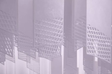 Tavandan sarkan bir dizi geometrik desenli kağıt fener. Fenerler, şebeke benzeri bir dizaynla dikdörtgen şeklindedir. Beyaz, hafif ışıklandırılmış arka plan üzerine karmaşık gölgeler bırakırlar.