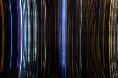 Siyah arkaplana karşı hareket eden ışıkların soyut bulanıklığı, harekete odaklan