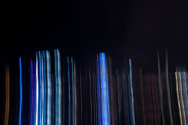 Siyah arkaplana karşı hareket eden ışıkların soyut bulanıklığı, harekete odaklan