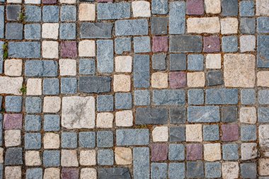 Çakıl taşı kaldırım, taşlar düzensiz şekilli ve boyutlarda, ve esasen gri ve bej / ten tonlarında, birkaç kırmızı-kahverengi taş karışımı