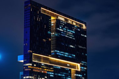 Geceleri çok katlı ofis binasında fazla mesai yapan işçiler var. Geç saatte ofiste. ışıklandırma ve çalışan insanlar