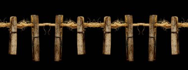 Eski ahşap mandallar, çamaşır askıları, kenevir ipinde, karanlık arka planda.