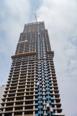 Merkezi sarı vinç ve asansörlerle inşa halinde bir gökdelen.