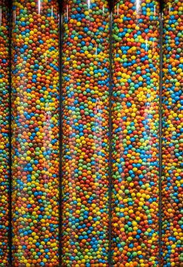 Farklı tipte renkli şekerlerle dolu şeffaf tüpler.