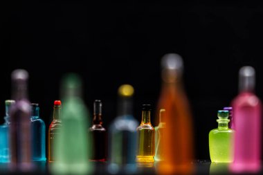 Siyah arka planlı etiketsiz çeşitli minyatür alkol şişeleri