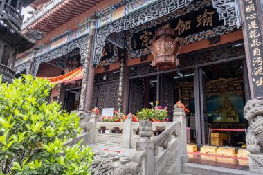 Chongqing, Çin - 09 Mayıs 2025 Chongqing, Çin 'in Jiulongpo Bölgesi, Huayan Tapınağı' ndaki geleneksel bir Çin Budist zen tapınağı, doğal manzarayı antik mimariyle harmanlıyor.