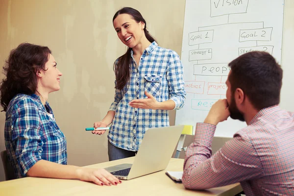 Woman standing hear flipchart and telling — Stock Photo, Image