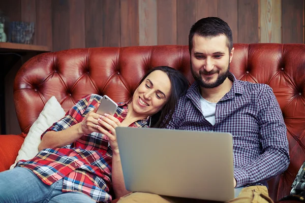 Casal usando smartphone e laptop — Fotografia de Stock