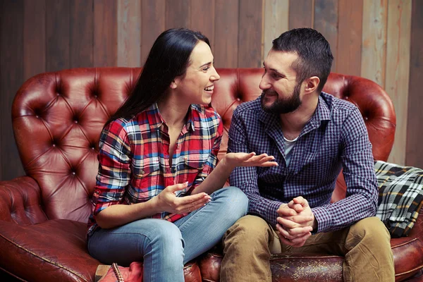 Пара сидит на диване и приятно поговорить — стоковое фото