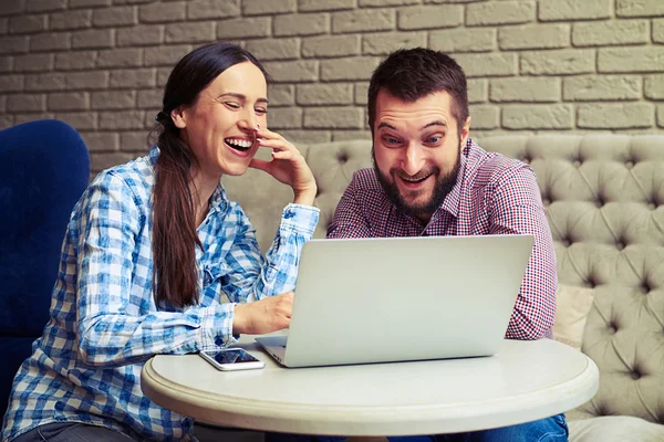 Γέλιο ζευγάρι ψάχνει στο φορητό υπολογιστή στο σπίτι — Φωτογραφία Αρχείου