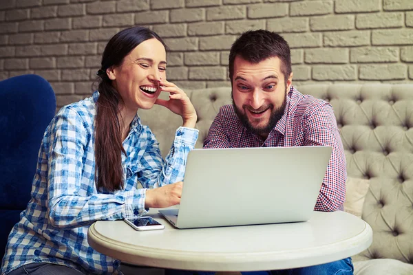 Lachen paar laptop thuis kijken — Stockfoto