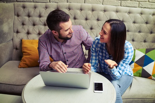 Caucasian couple sitting on sofa and talking — Stock Photo, Image