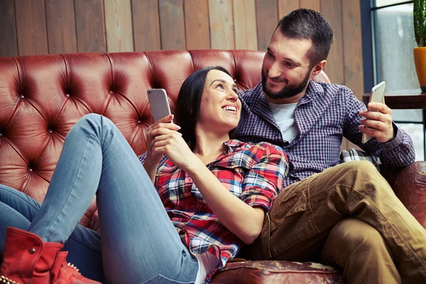 웃는 남자와 여 자가 소파에 휴식 — 스톡 사진