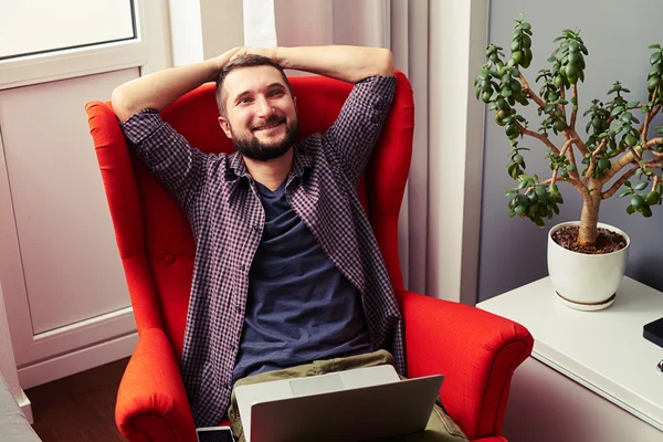 Man sitter på stolen med laptop och letar upp — Stockfoto