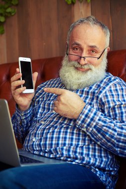 adam kanepede oturan ve cep telefonu işaret