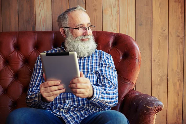 Homem sentado com tablet pc com bom humor — Fotografia de Stock