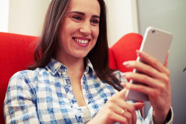 Smartphone vasıl seyir ve gülümseyen kadın