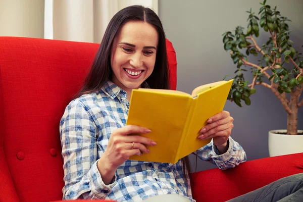 Kadın sandalyede oturan ve kitap okuma — Stok fotoğraf