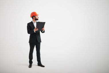 Kenara bir siyah takım elbise ve inşaat kask içinde adam