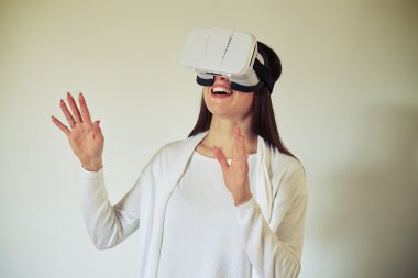 Sahip kadın beyaz sanal gerçeklik kulaklık kullanarak eğlenceli
