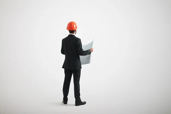 Back view of standing man in formal wear and a hard hat — Stock Photo, Image