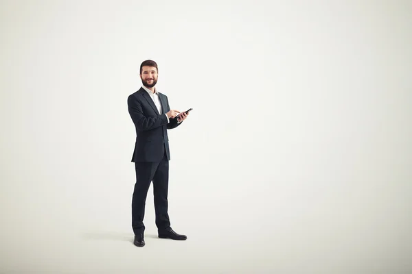 Homme d'affaires dans une tenue formelle avec téléphone noir dans ses mains — Photo