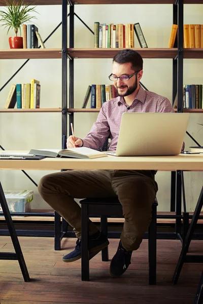 Geschäftsmann sitzt auf einem Stuhl und macht sich Notizen — Stockfoto