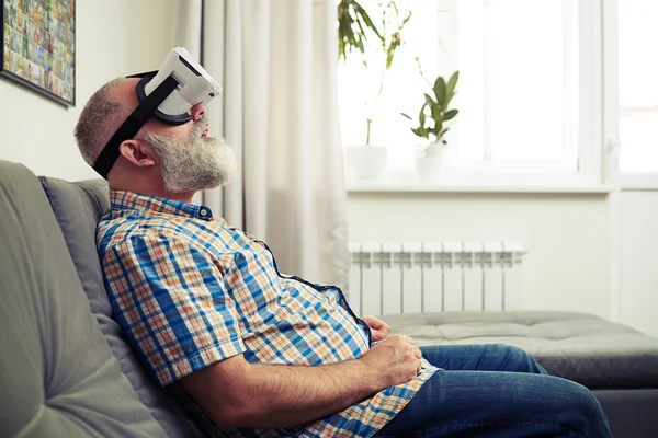 Hombre guapo divirtiéndose usando auriculares modernos de realidad virtual —  Fotos de Stock