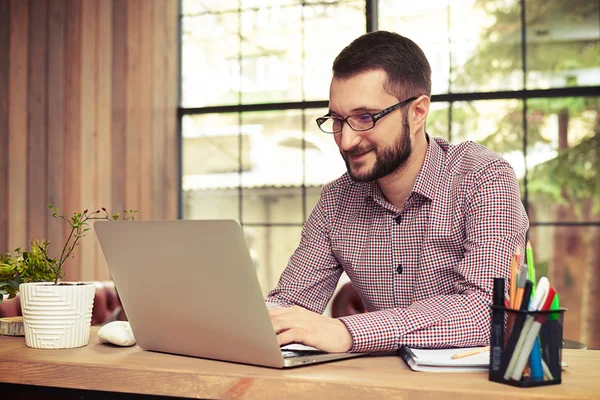 Hombre feliz escribiendo en su portátil — Foto de Stock