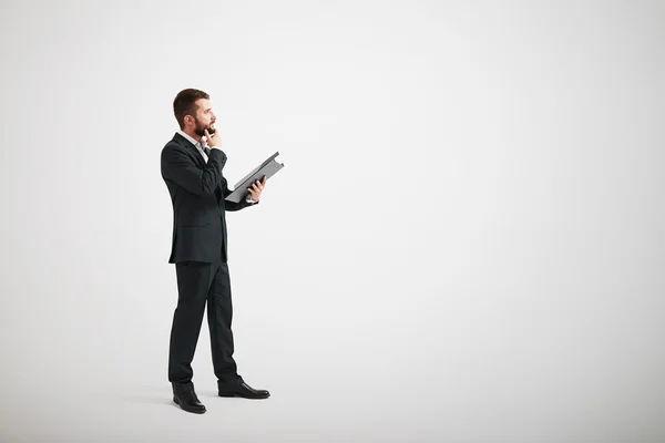 Hombre en un traje formal tocando su barba y mirando hacia adelante —  Fotos de Stock